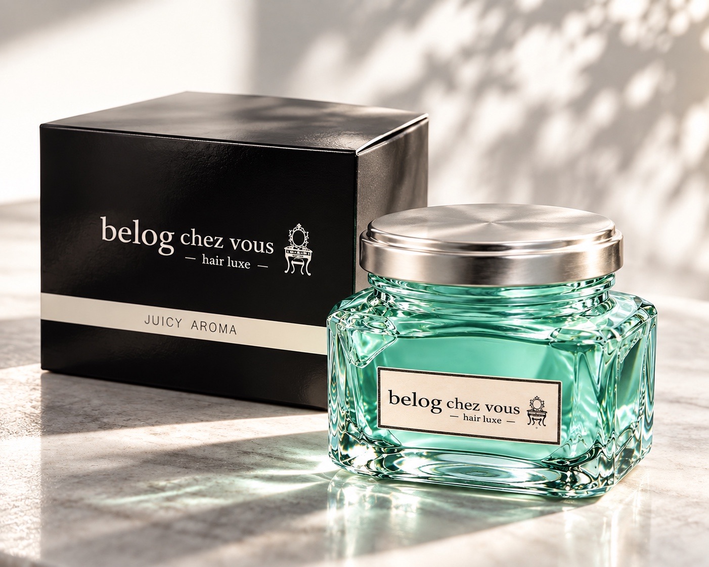 黒の箱と並ぶ、シルバーの蓋と透明感のある淡いブルーのヘアジェル(belog chez vous ― hair luxe ―、JUICY AROMA)